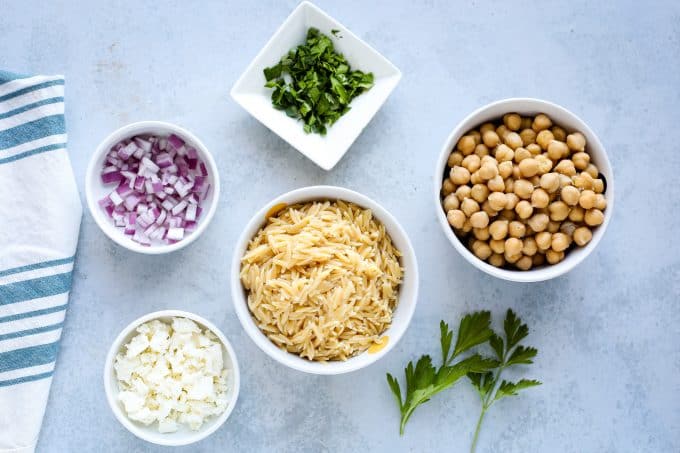 orzo pasta salad ingredients including orzo, onion, chickpeas, and feta