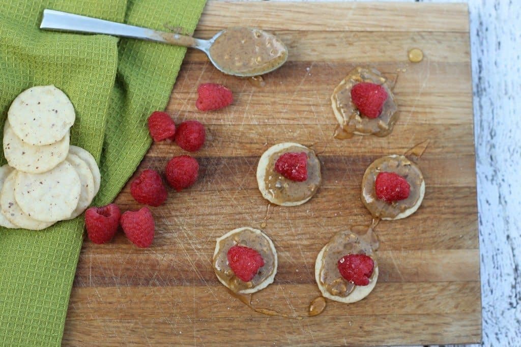 almond butter and raspberries on a cutting board