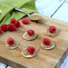 Try this super simple snack! It's just raspberries with almond butter and honey on a cracker!