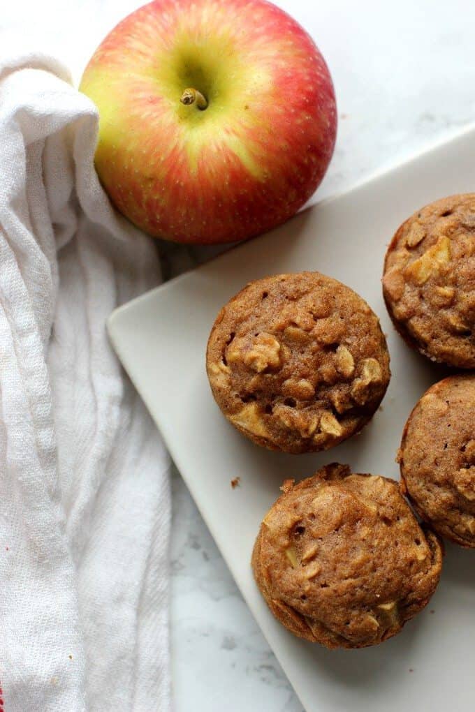 apple cinnamon muffins next to an apple