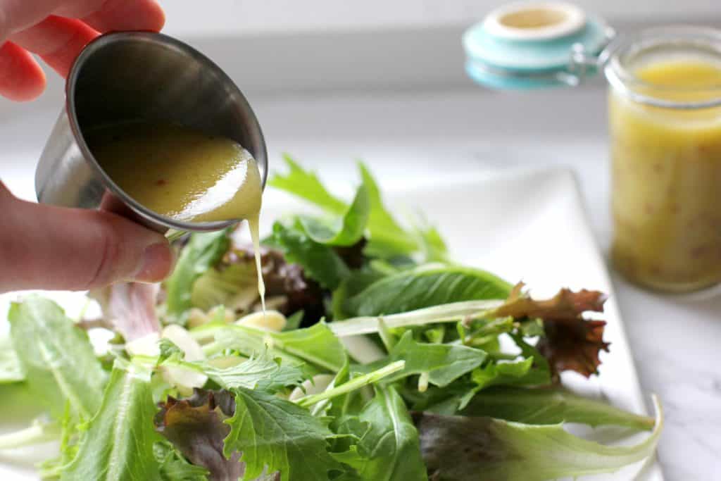 Salad dressing being poured on a salad