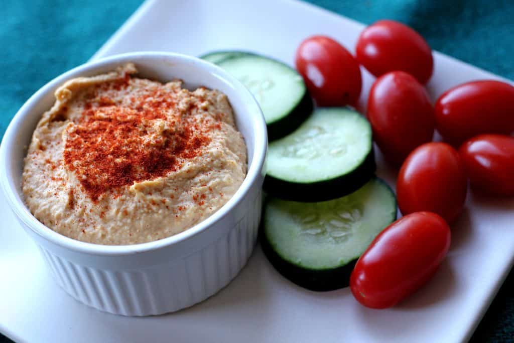 paprika hummus on a plate with veggies