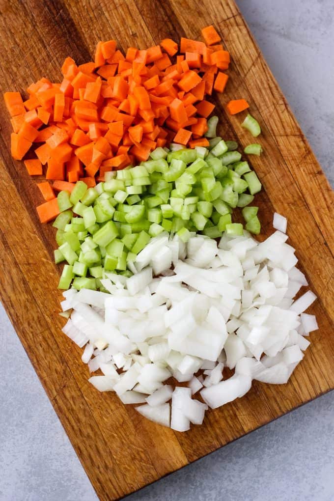 Mirepoix on top of a wooden cutting board 