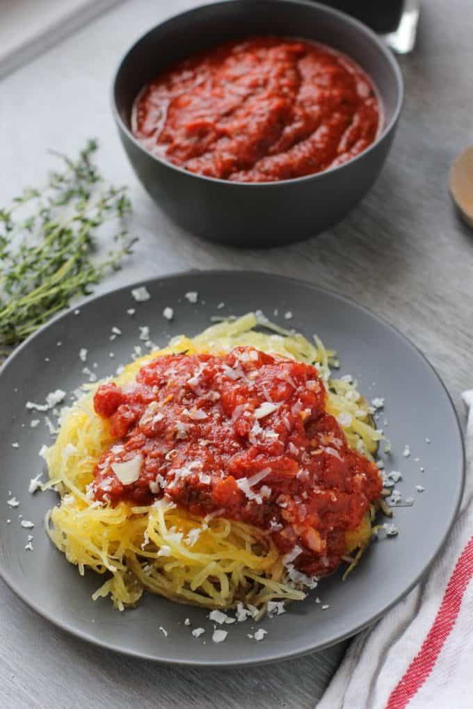 spaghetti squash next to a bowl of sauce