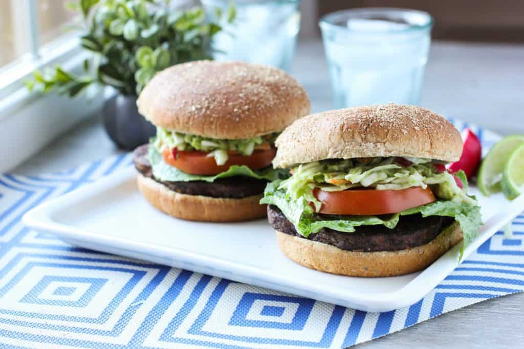 burgers on a white plate with a blue placemat