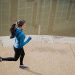 A young girl running on a sidewalk