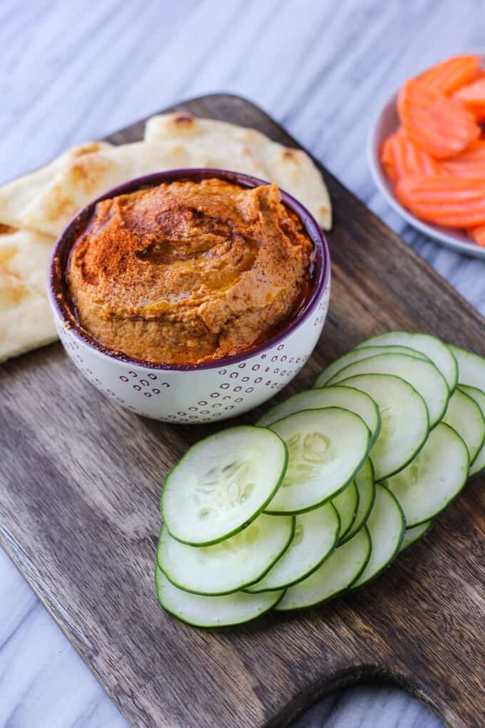 A close up of food on a wooden table, with Hummus
