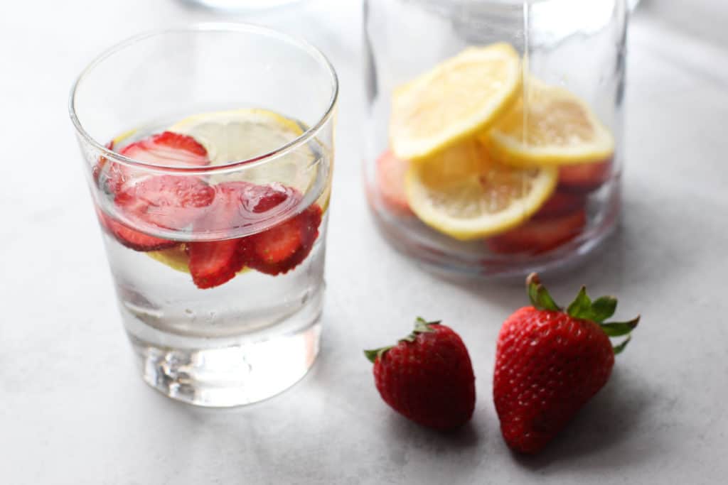 A glass of water, with Strawberry and Lemon