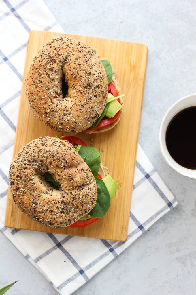 two bagel sandwiches on a cutting board