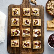 Crackers on a cutting board with toppings