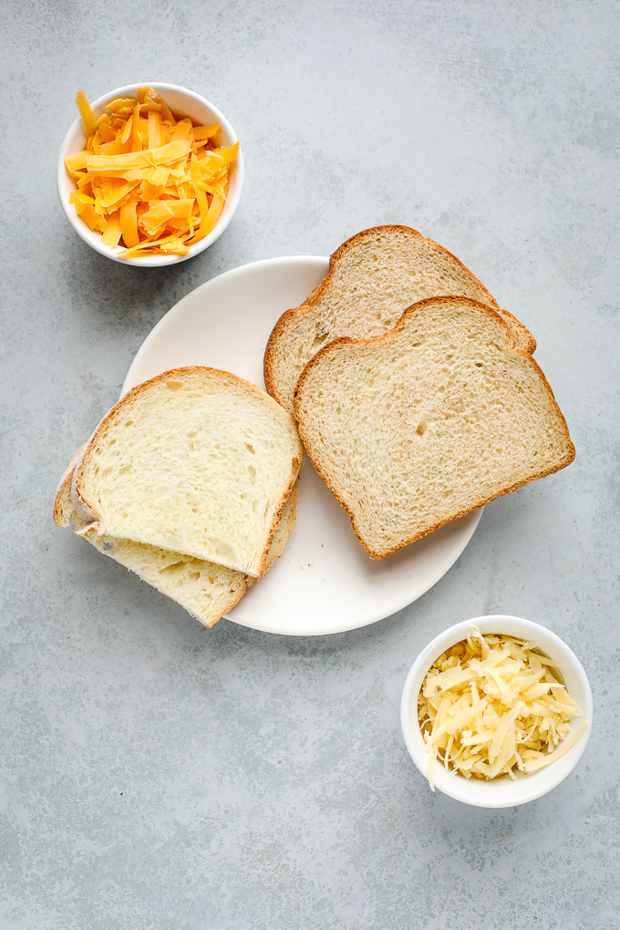 A plate of food with a slice of bread, with Cheese and Sandwich