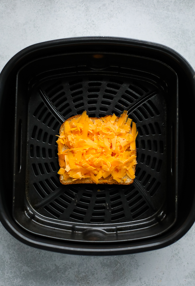 air fryer basket with a grilled cheese inside
