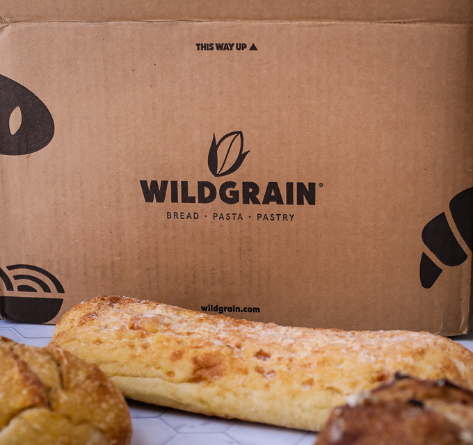 A close up of a box of food, with Wildgrain and Bread