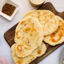 A plate of naan on a cutting board