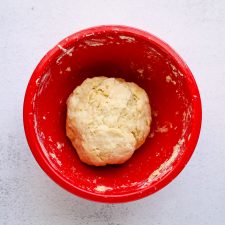 A ball of flatbread pizza dough in a bowl