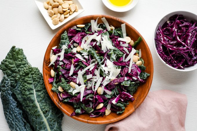 Lacinato kale salad in a bowl with shredded cheese