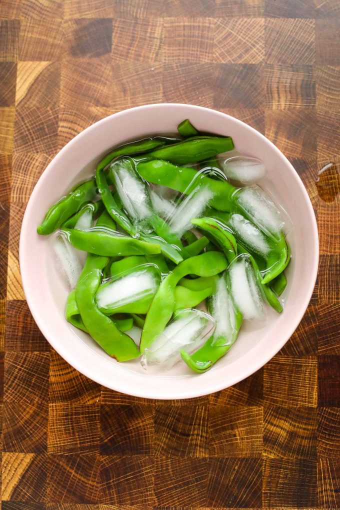 romano beans in a bowl of ice water