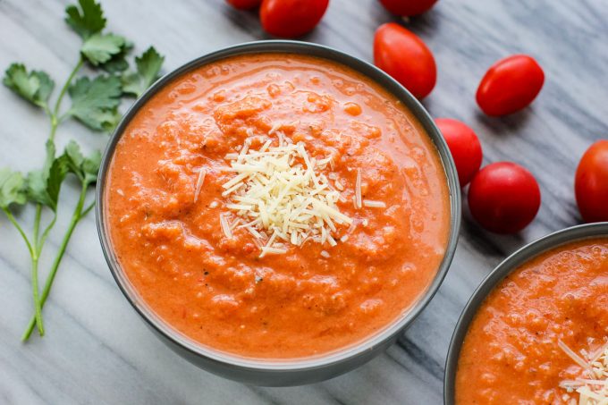 creamy tomato soup in a bowl topped with cheese