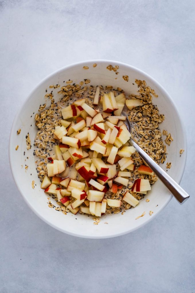 A bowl of oatmeal with chopped apples 