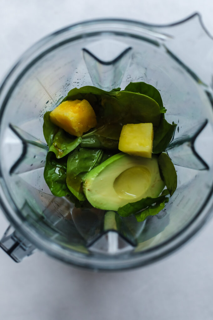 avocado, spinach, and pineapple in a blender