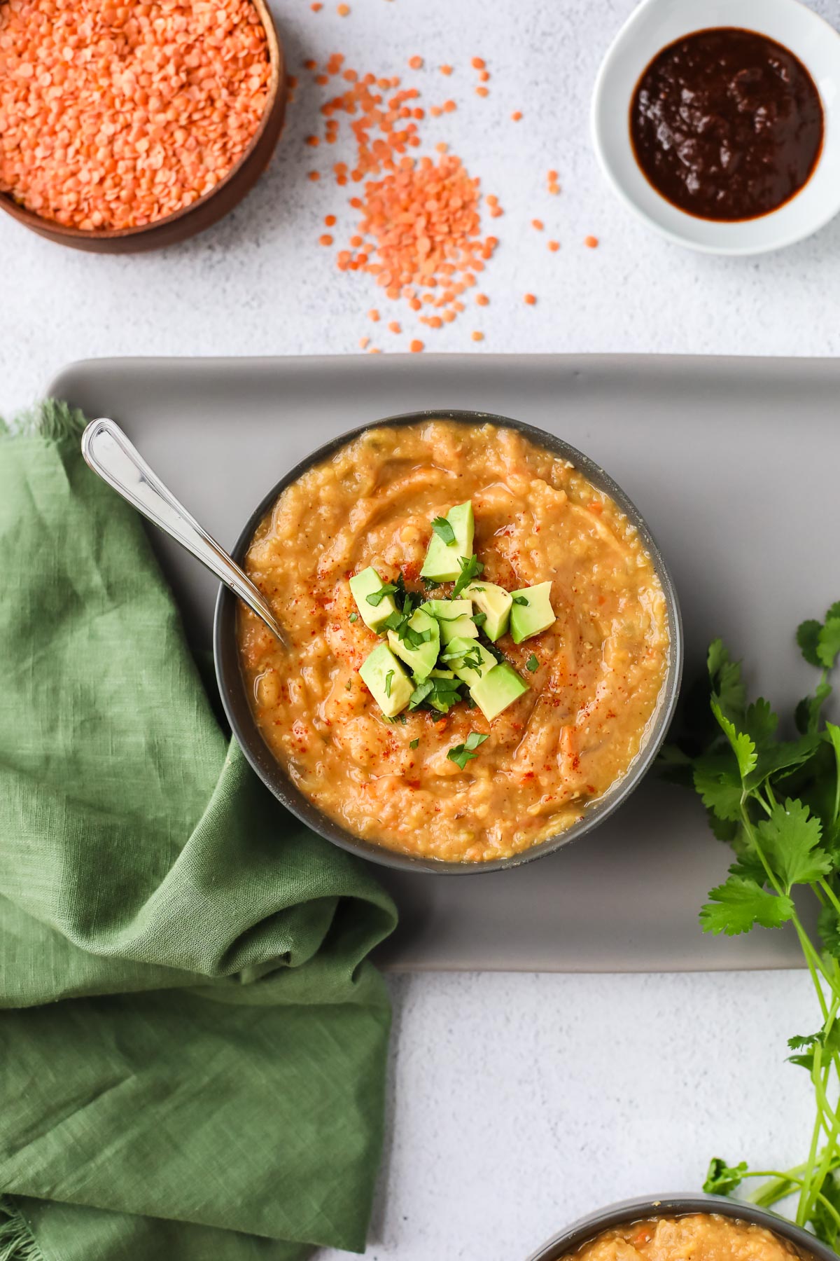 red lentil soup topped with avocado