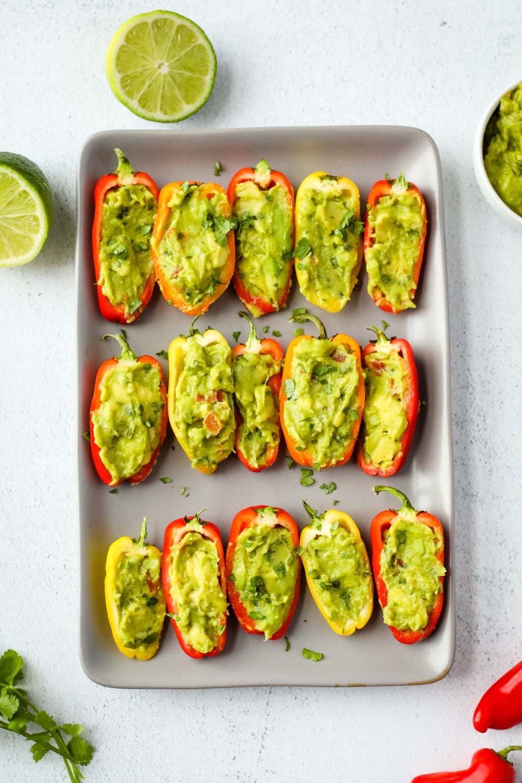 Mini sweet peppers stuffed with fresh guacamole and garnished with cilantro for 4th of July party bites